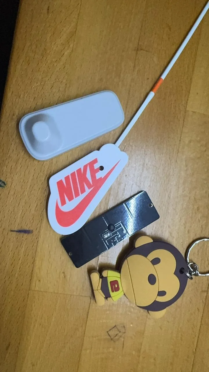 RFID asset tags and a keyfob tag beside a handheld reader antenna