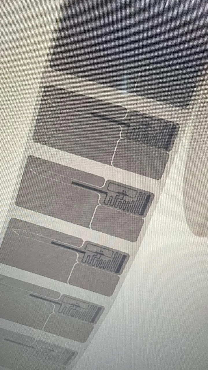 RFID inlay web on a roll showing the antenna pattern and chip