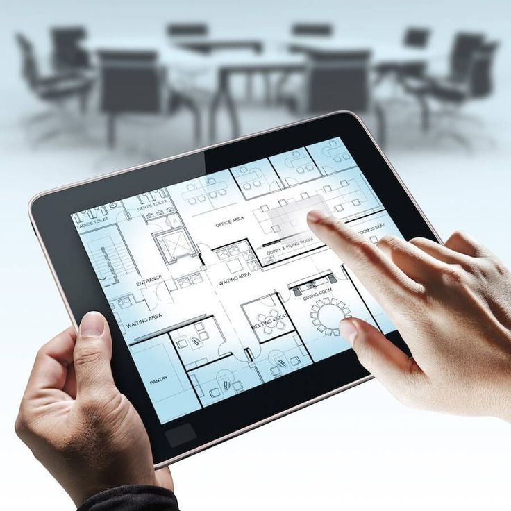 Facility manager reviewing an office floor plan on a tablet showing meeting rooms, workspace and service areas
