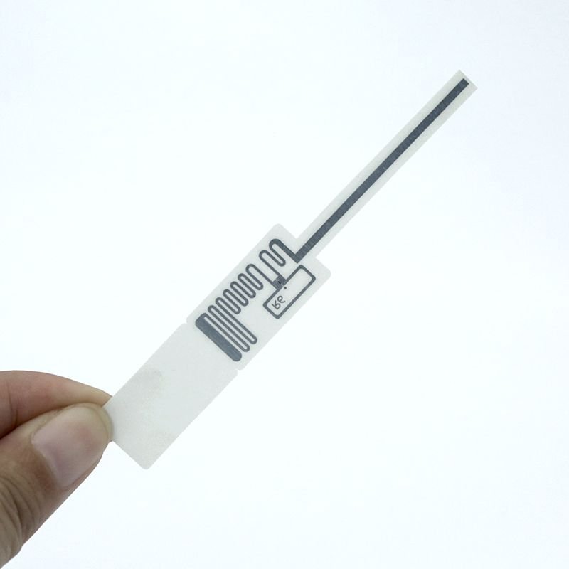 UHF RFID tag inlay held in hand showing the antenna and chip
